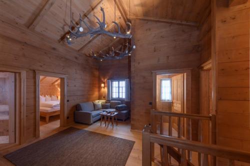 a living room with wooden walls and a chandelier at Chalet Berghaus Gauertal in Schruns