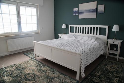 a bedroom with a white bed and two windows at Oelgemoellers Hus in Lohne