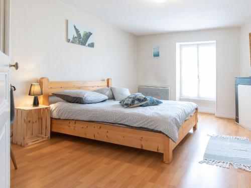une chambre avec un lit en bois dans une pièce dans l'établissement Mâcon - Gare - Centre Ville - Parking - Cosy - Wifi, à Mâcon