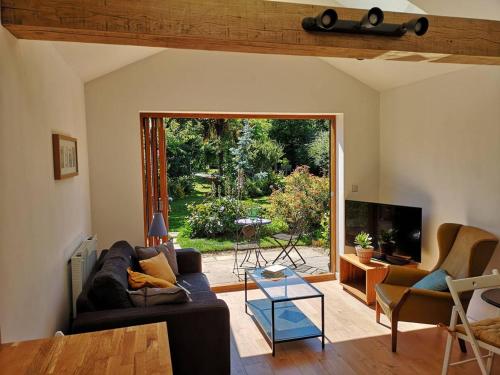 a living room with a couch and a sliding glass door at The Bird House at Woodburn Cottage in Dedham