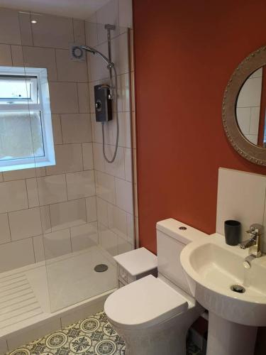 a bathroom with a toilet and a sink and a shower at The Bird House at Woodburn Cottage in Dedham