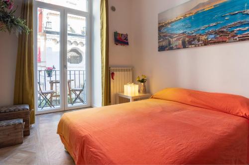 um quarto com uma cama laranja e uma varanda em Il Balcone Sui Presepi Apartment em Nápoles