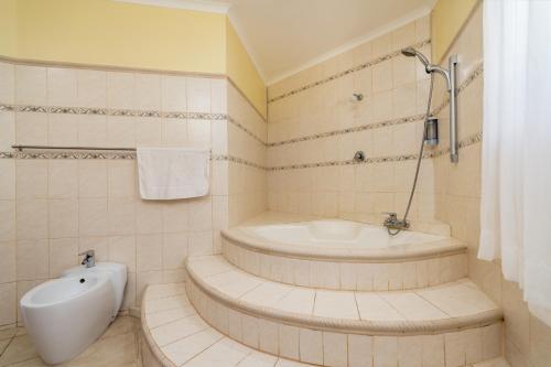 a bathroom with a bath tub and a sink at Carana Hilltop Villa Seychelles in Glacis