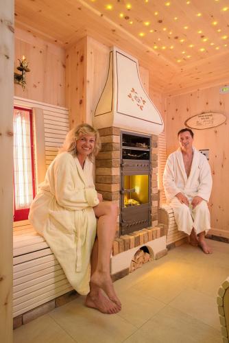 a man and a woman in a room with a fireplace at Wellness Privathotel Post an der Therme in Badenweiler