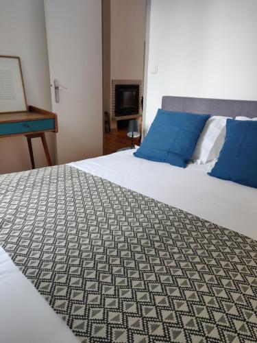 a bedroom with two beds with blue pillows at Suite Hôtel de Ville - Cathédrale in Clermont-Ferrand