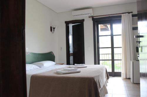 a bedroom with a bed with two towels on it at Pousada Blauberg in Pomerode