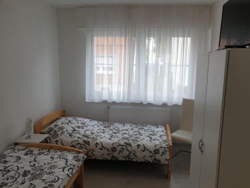 ein kleines Schlafzimmer mit einem Bett und einem Fenster in der Unterkunft Wohnung, Zimmer in Frankfurt Flughafen zu vermieten in Mörfelden-Walldorf