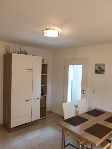 eine Küche mit einem Tisch und einem weißen Kühlschrank in der Unterkunft Wohnung, Zimmer in Frankfurt Flughafen zu vermieten in Mörfelden-Walldorf