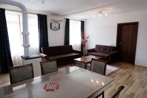 a living room with a couch and a table and chairs at Hotel Kings Apartments in Kolgecaj