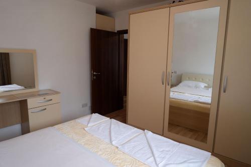 a bedroom with a large glass closet with a bed at Hotel Kings Apartments in Kolgecaj