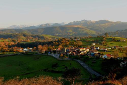 a small town in a field with mountains in the background at Alojamiento Bernabales in Pámanes