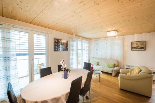 a living room with a table and a couch at Bellavista - Direct lake view in Brienz