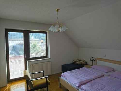Križe的住宿－Sobe Janez，一间卧室配有一张床、一把椅子和一个吊灯。