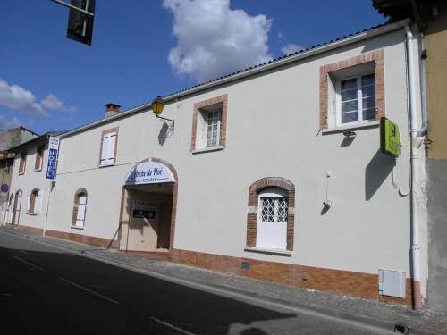 a white building on the side of a street at Logis Hôtel L'Arche de Noé in Noé