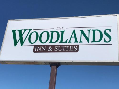 a sign for the woodlands inn and suites at Woodland Inn & Suites in Medford