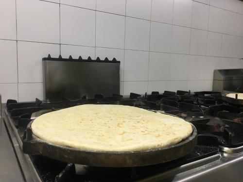 a pizza cooking in a pan on a stove at hotel dei consoli in Gubbio