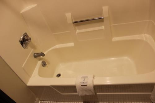 a white bath tub in a bathroom with a toilet at Woodland Inn & Suites in Medford