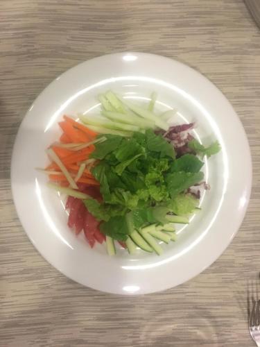 a white plate of vegetables on a table at hotel dei consoli in Gubbio