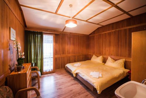 ein Schlafzimmer mit einem Bett und einem Waschbecken darin in der Unterkunft Bellerive in Brienz