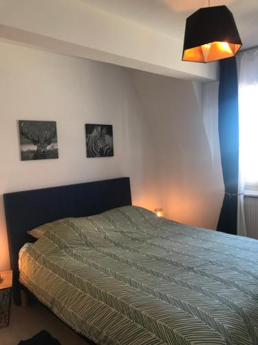 - une chambre avec un lit et une lampe dans l'établissement Le petit coin de Paradis, à Varaville