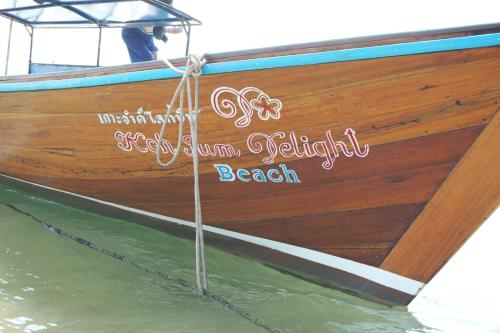 a wooden boat is tied up on the water at Koh Jum Delight Beach in Ko Jum