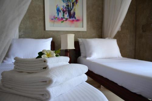 a hotel room with two beds with white towels at Amani Residence Beverly Suites in Malindi