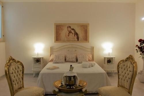 Schlafzimmer mit einem Bett mit 2 Stühlen und einem Tisch in der Unterkunft De Mola Holiday House in Pezze di Greco