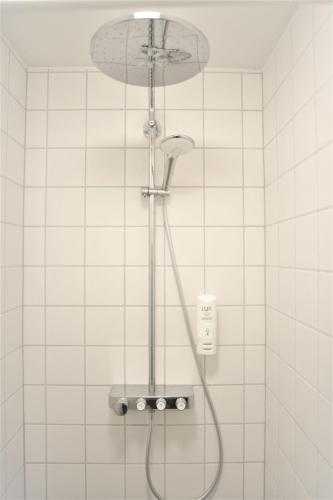 a shower with a shower head in a bathroom at Nuuk City Hostel in Nuuk