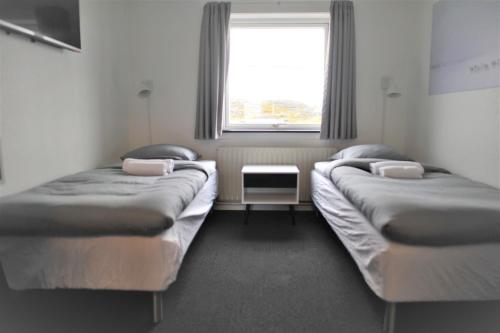 2 Betten in einem Zimmer mit Fenster in der Unterkunft Nuuk City Hostel in Nuuk