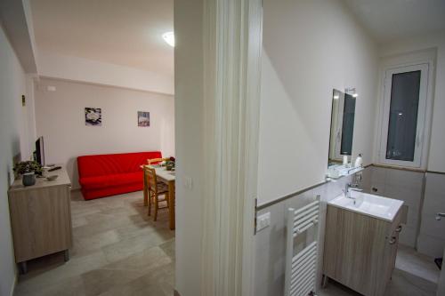 a living room with a red couch and a table at Case Vacanze Blue Sea in Mascali
