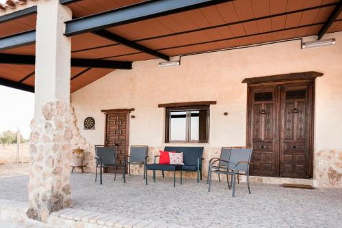 a patio with chairs and a table in front of a building at Casa Rural Las Caleras in Daimiel