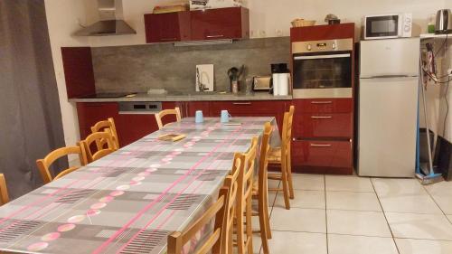 - une cuisine avec une grande table, des chaises et un réfrigérateur dans l'établissement Les Diats 1811, à Corrençon-en-Vercors