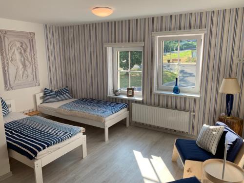 a room with two beds and two windows at FeWo Skiheim in Großschönau