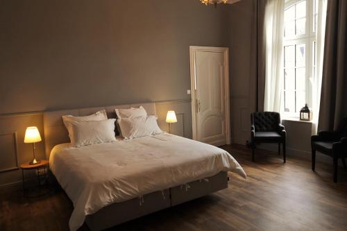 a bedroom with a large bed with white sheets and pillows at Villa de Noailles in Spa