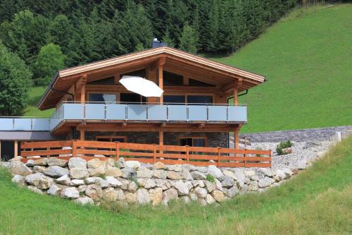 a log cabin with a balcony on top of a stone wall at Mountain Chalet R in Berwang