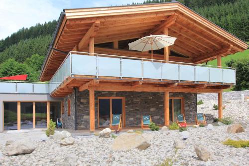 ein Haus mit Balkon und Sonnenschirm in der Unterkunft Mountain Chalet R in Berwang