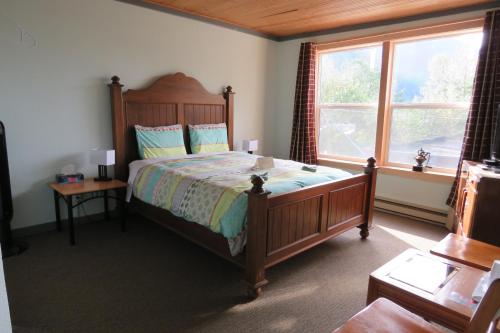 a bedroom with a large bed and a window at Historic Hotel Bayview in Stewart