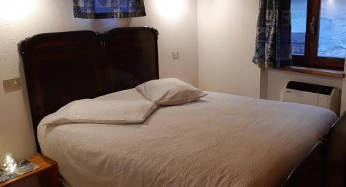 a bedroom with a bed with a large headboard and a window at Casetta con camino in La Magdeleine