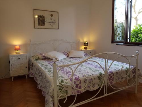 a bedroom with a white bed and two night stands at Apartman Gabrijela in Mali Lošinj