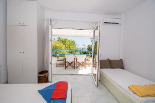 a bedroom with a bed and a view of a patio at Romantic Seafront Studio - Dream Garden in Platanidia