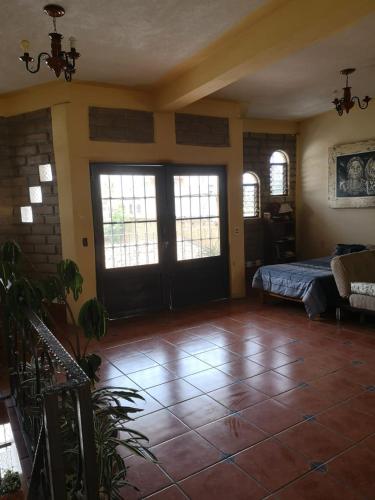 a room with a bedroom with a bed and windows at Loft El Rosario in Tlayacapan