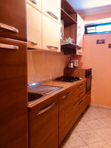 a kitchen with wooden cabinets and a stove top oven at Armonia B&B in Aquino
