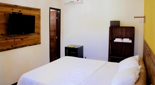 a bedroom with a bed and a flat screen tv at Pousada Stella Tropical in Salvador