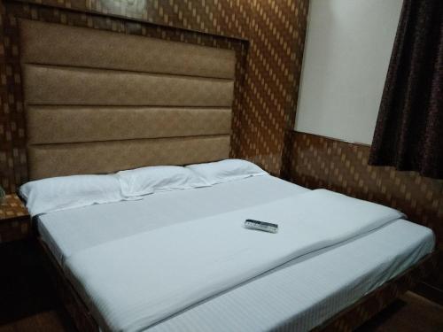 a bed with a remote control sitting on top of it at Silver Palace Hotel in New Delhi