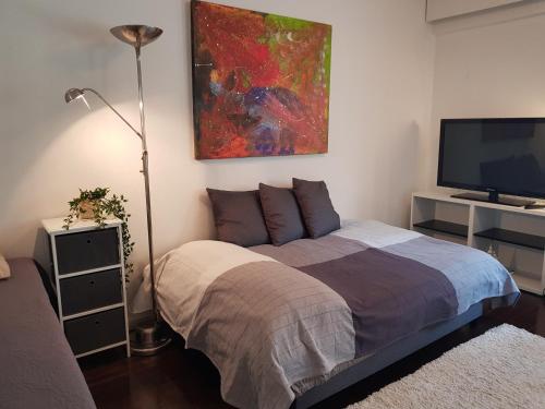 a bedroom with a bed and a flat screen tv at HomeAway City in Kuopio