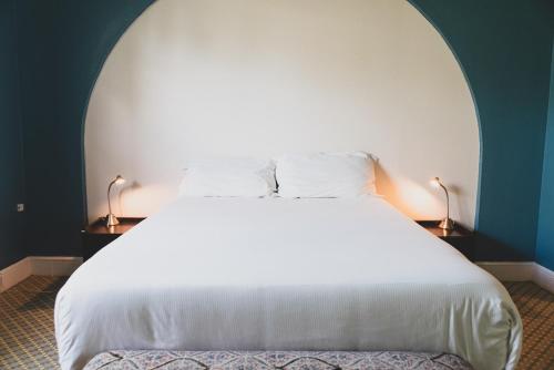 a bedroom with a white bed and two lamps at Numero Uno Beach House in San Juan