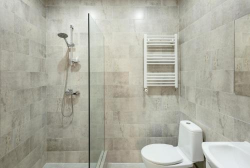 a bathroom with a shower with a toilet and a sink at Brick walls in Gori