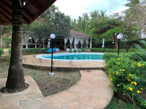 a swimming pool in a yard with a house at Villa Ameera Malindi in Malindi
