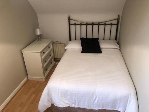 a bedroom with a bed with a black pillow on it at No. 7 Lissadell Holiday Home in Portstewart