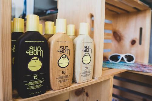 three bottles of sunscreen sitting on a shelf at Numero Uno Beach House in San Juan